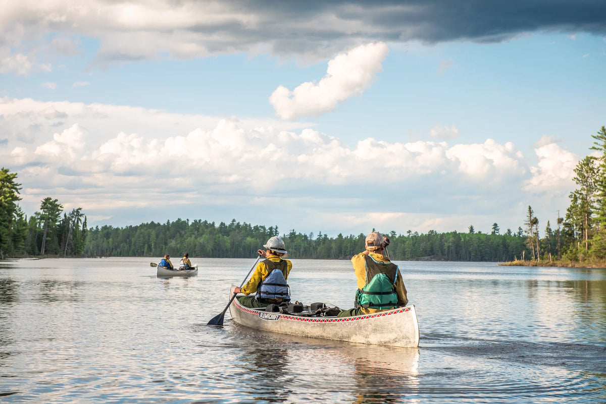 Wildland firefighters in an alumacraft canoe paddling on a remote lake. Duluth Pack X Wildland Firefighter Foundation. Photo by Kyle Miller