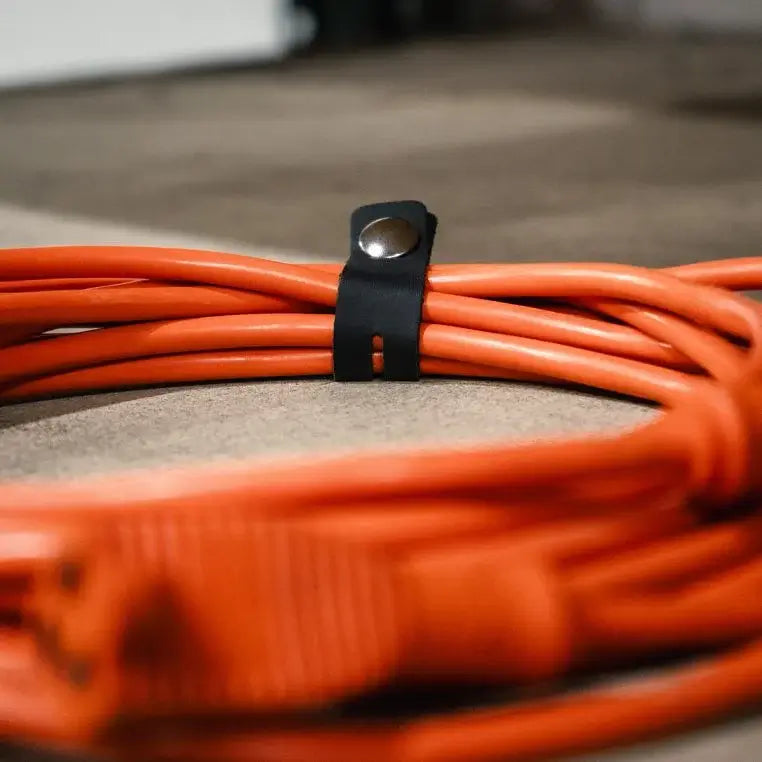 Leather Cord Organizer Being Used On An Orange Extension Cord