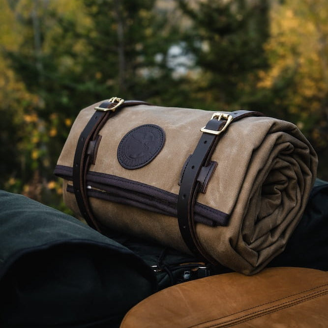 Duluth Pack Bedroll sitting on a backpack with a fall forest in the background.